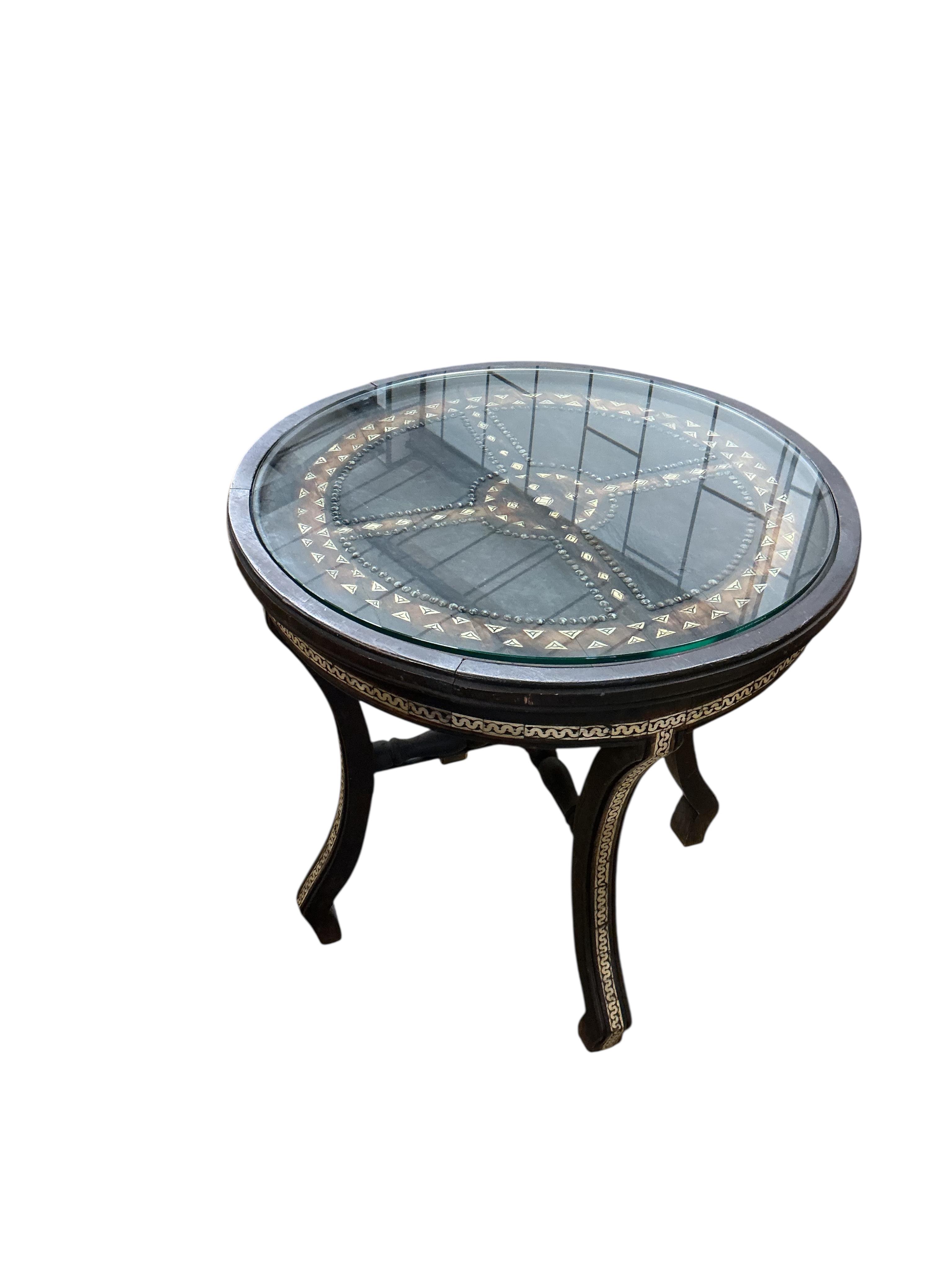 A Moroccan circular studded cedar glass top bistro table, diameter 80cm, height 76cm together with two matching chairs